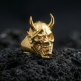 Load image into Gallery viewer, Sterling silver oni skull ring in polished silver finish on volcanic rock, detailed horned mask carving and fangs, close-up photo
