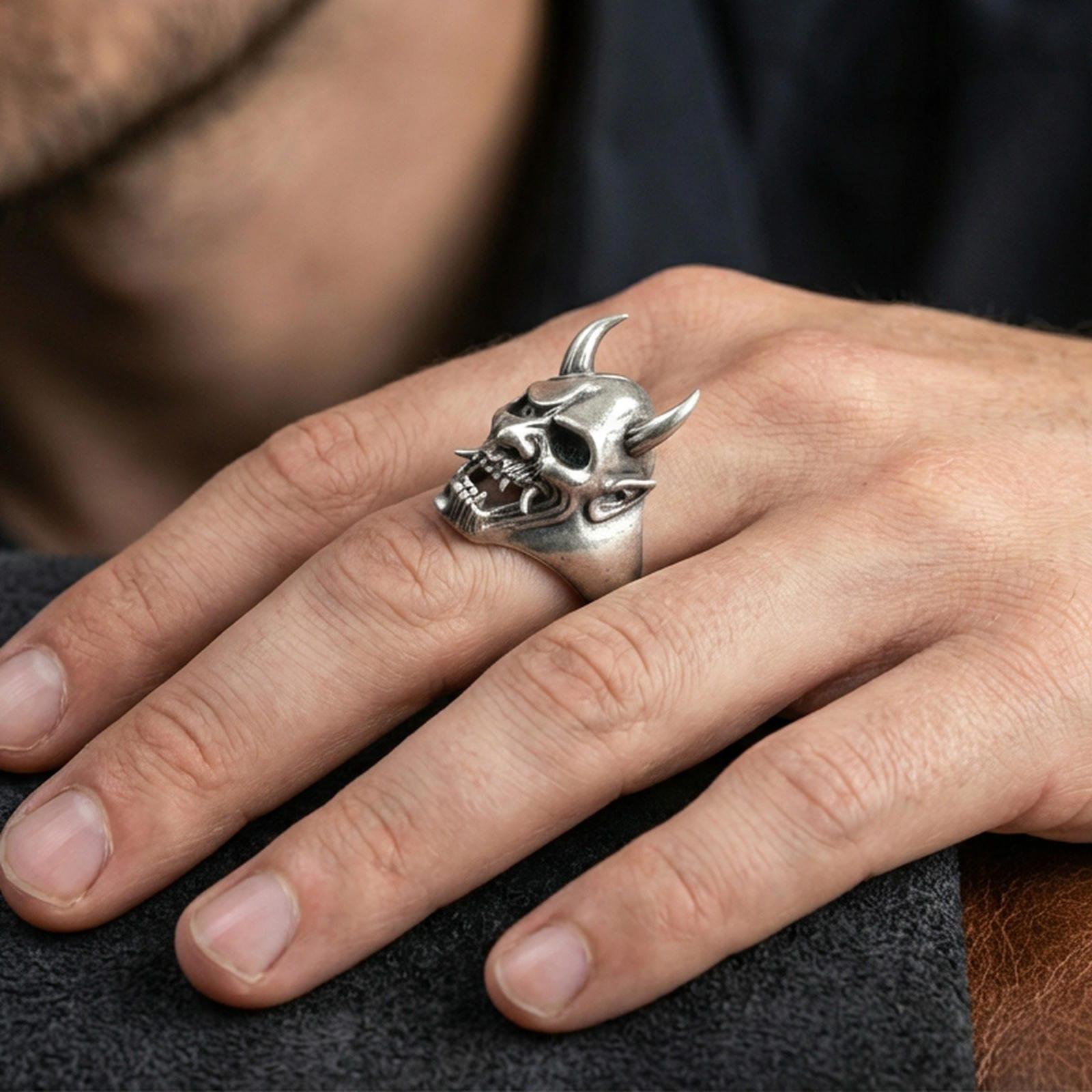 Sterling silver undead oni mask ring in an oxidized finish worn on finger, horned Japanese yokai skull detail visible, lifestyle hand close-up