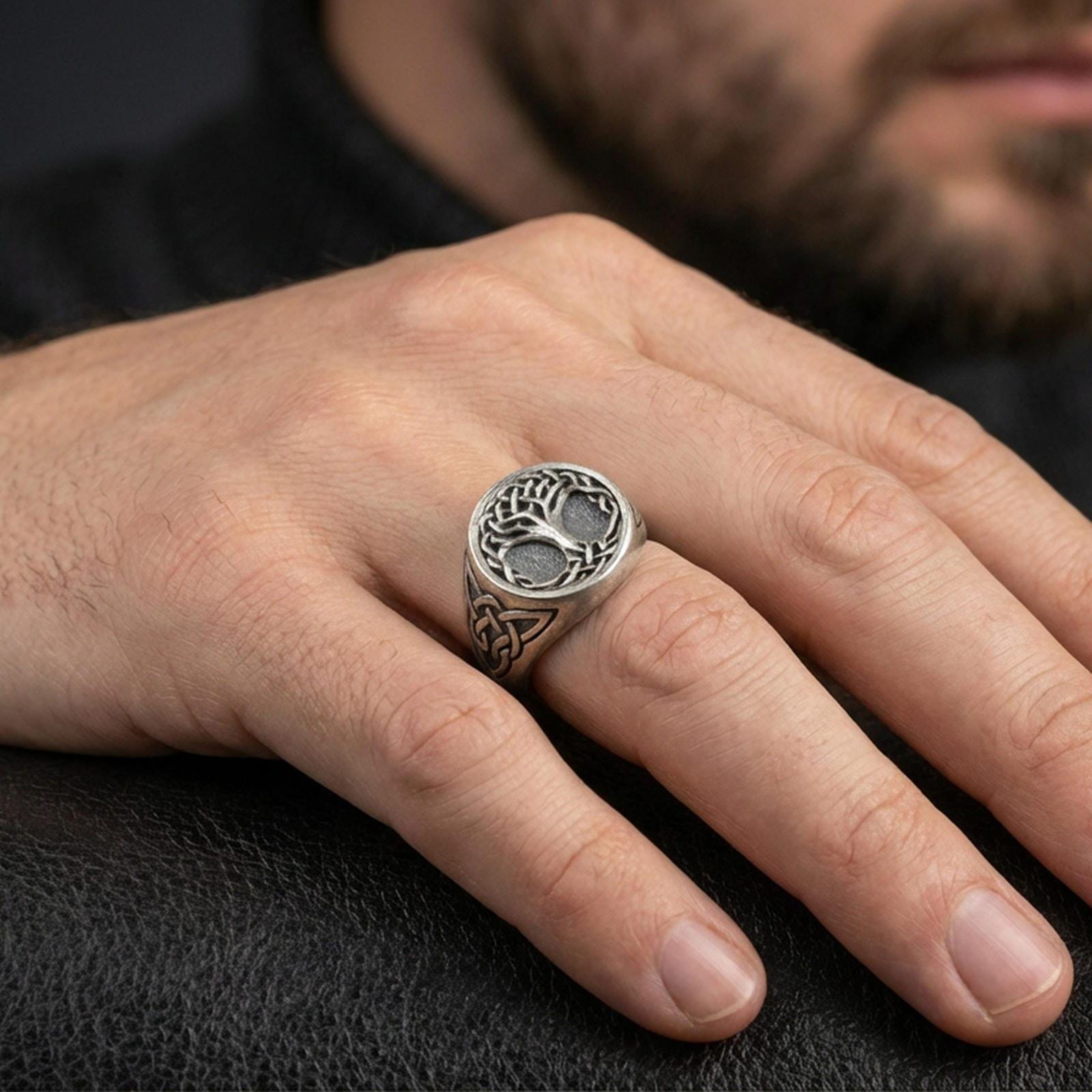Sterling silver Celtic Yggdrasil ring in an oxidized finish worn on finger, Tree of Life symbol and knotwork visible, lifestyle hand close-up