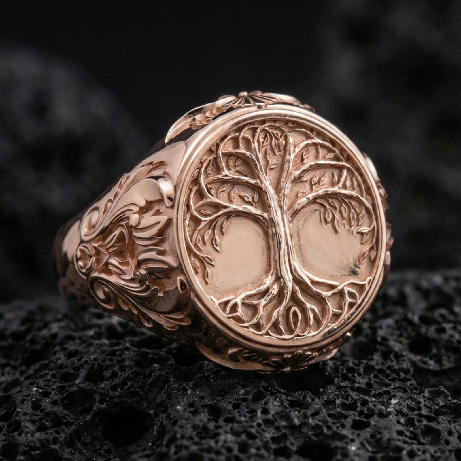 Yggdrasil tree of life ring in a rose gold plated finish on volcanic rock, intricate roots-and-branches motif with engraved side panels, luxury studio close-up