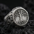 Load image into Gallery viewer, Sterling silver Yggdrasil tree of life signet ring in an oxidized finish on volcanic rock, Celtic-inspired branches and roots relief, macro studio product shot
