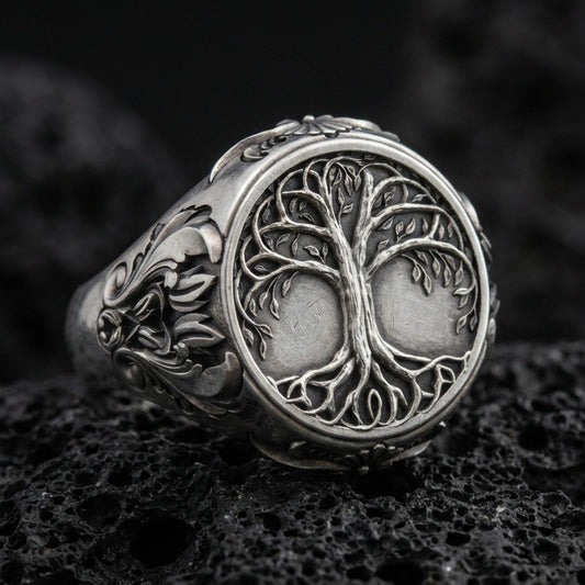 Sterling silver Yggdrasil tree of life signet ring in an oxidized finish on volcanic rock, Celtic-inspired branches and roots relief, macro studio product shot