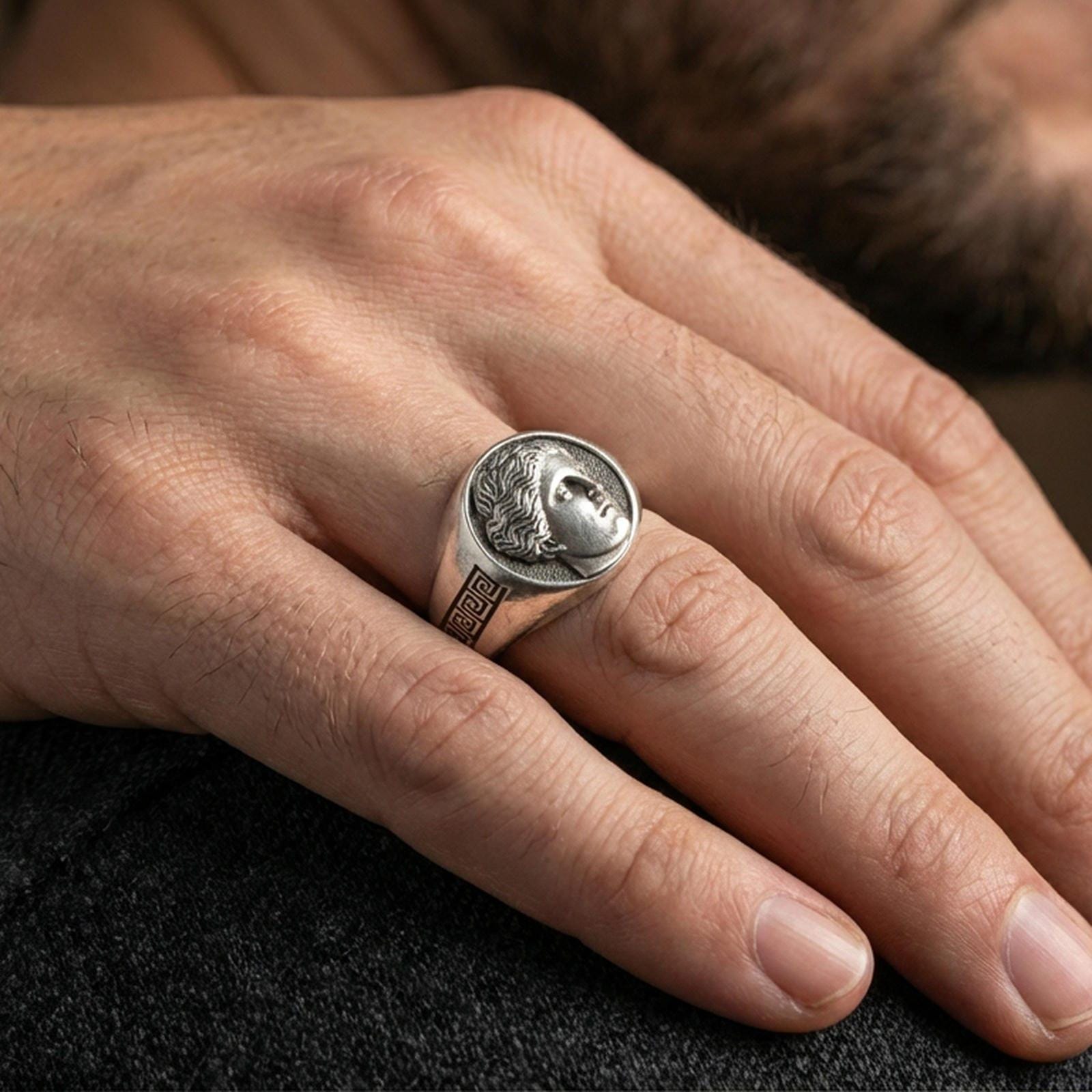 Sterling silver Venus goddess ring in an oxidized finish worn on finger, Roman portrait signet with Greek key shoulders, elegant lifestyle close-up