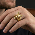 Load image into Gallery viewer, Japanese yokai oni ring in a gold plated finish worn on finger, fierce demon mask relief with horns, premium lifestyle jewelry shot
