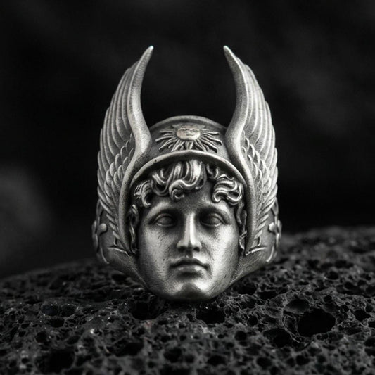 Sterling silver Hermes ring in an oxidized finish on volcanic rock, Greek god face with winged helmet relief, dramatic macro studio shot