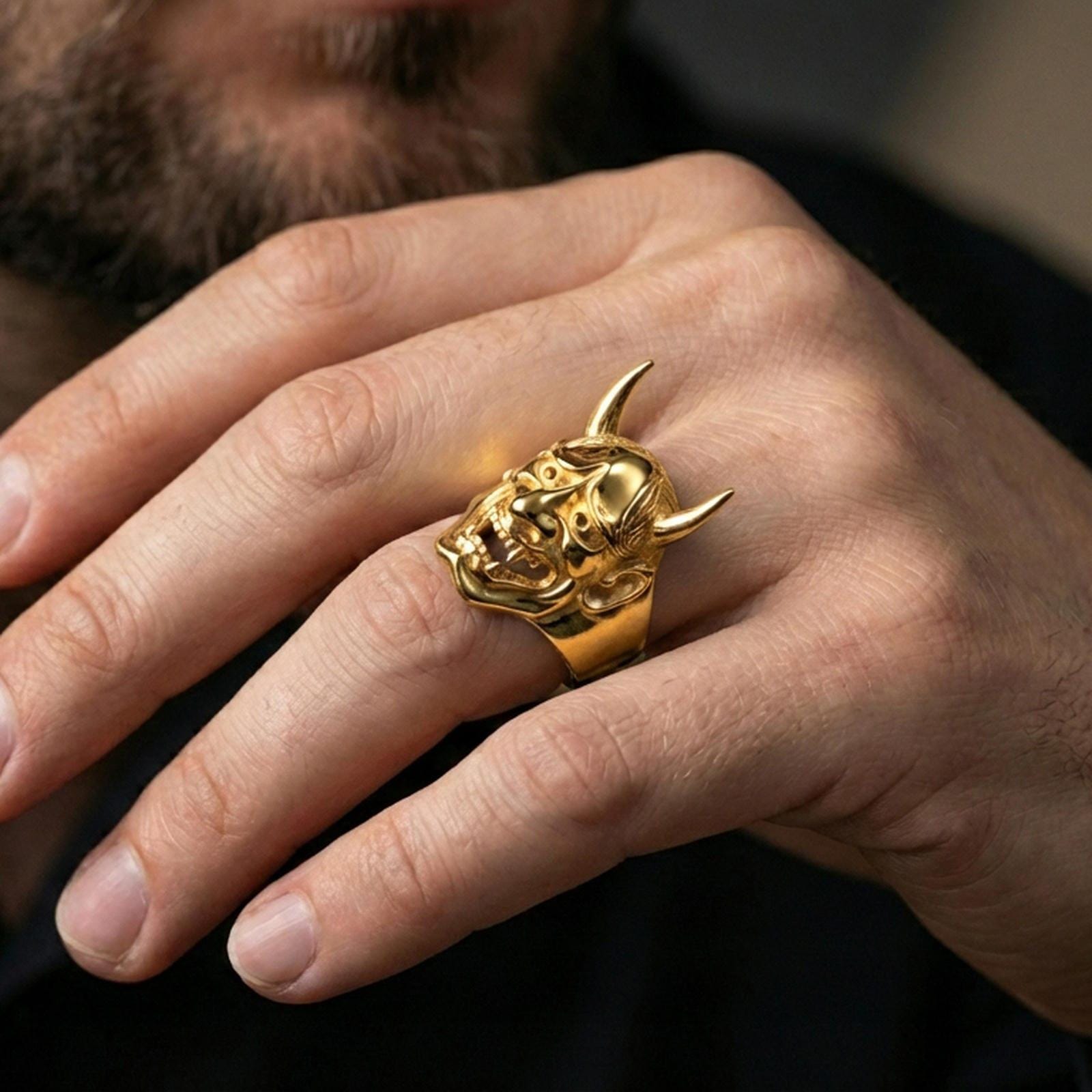 Japanese demon Hannya ring in a gold plated finish worn on finger, bold horned mask relief, premium lifestyle close-up