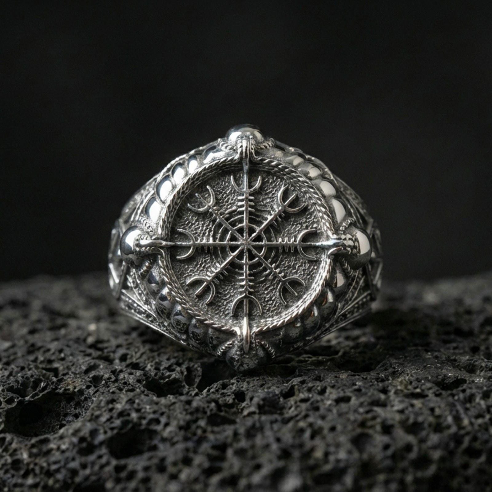 Vegvisir rune compass ring in polished silver finish on volcanic rock, detailed Norse stave engraving with clean shine, close-up product photo