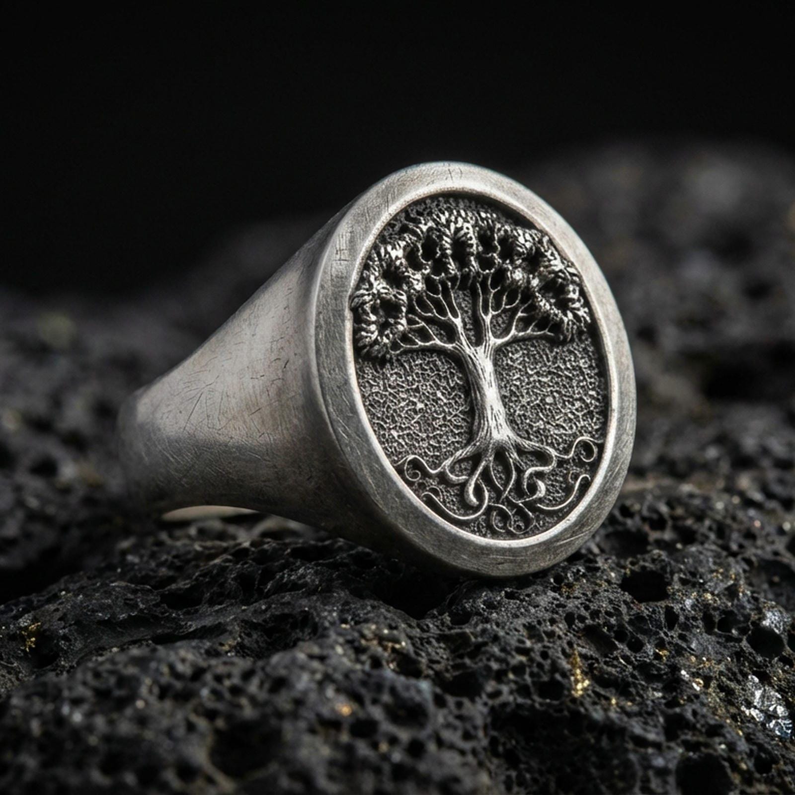 Sterling silver Tree of Life signet ring in oxidized finish on volcanic rock, Yggdrasil world tree, macro close-up