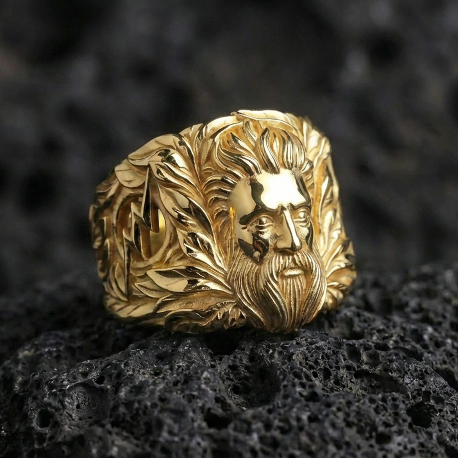 Zeus portrait signet ring in gold finish on volcanic rock, high-shine gold, crisp macro product shot