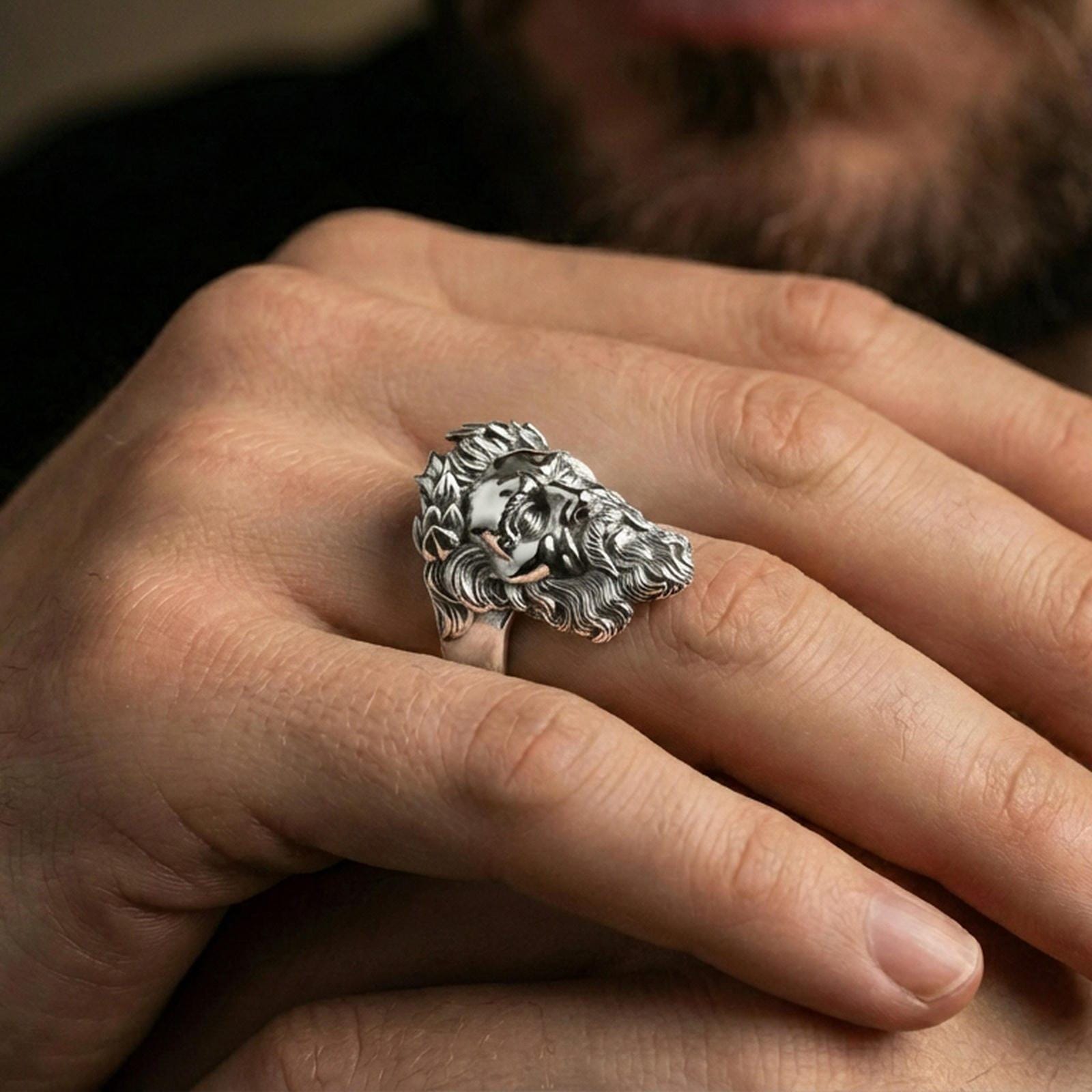 Polished silver Zeus ring on finger showcasing detailed beard and laurel wreath relief, clean lifestyle wear photo with natural lighting