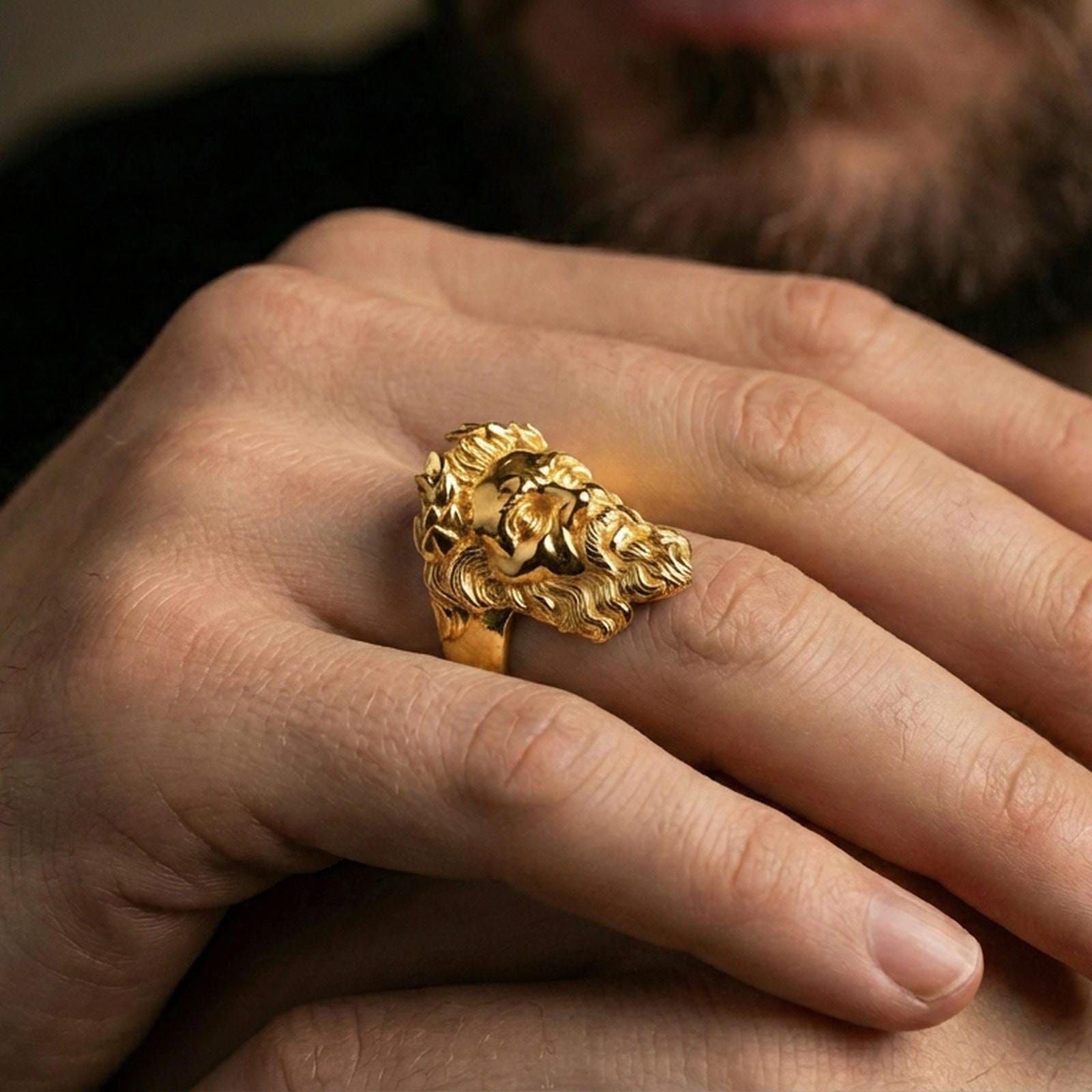 Gold plated Zeus mythology ring worn on finger, statement signet style with classical god portrait, premium lifestyle close-up