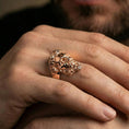 Load image into Gallery viewer, Rose gold plated Zeus ring on finger featuring ornate laurel wreath and sculpted face, refined lifestyle jewelry wear shot
