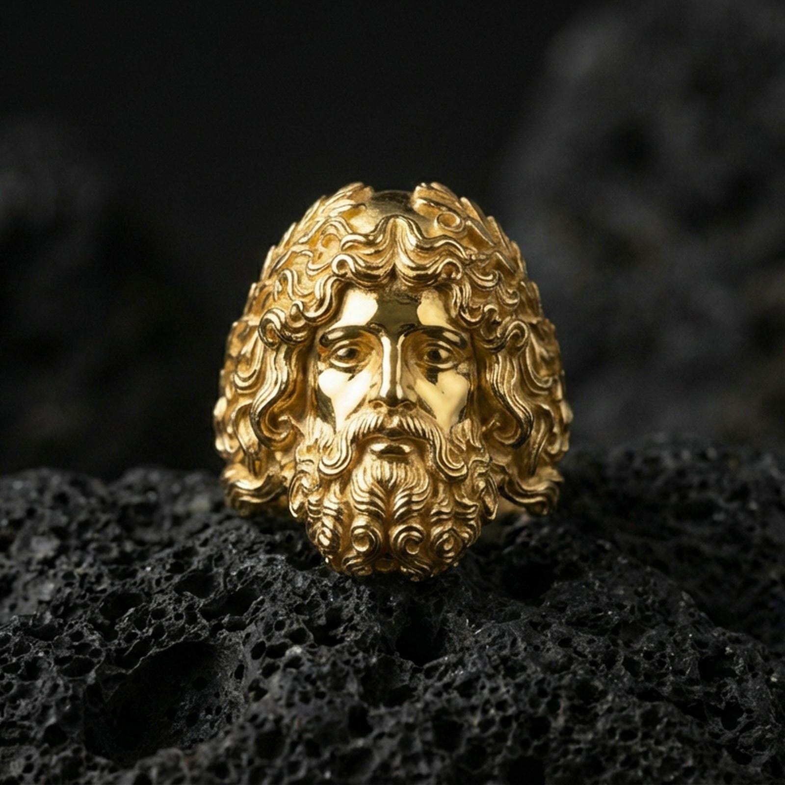 Gold plated Zeus signet ring featuring classical Greek god portrait and deep relief details, premium studio macro on black volcanic rock surface