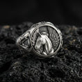 Load image into Gallery viewer, Detailed Pegasus ring crafted in oxidized sterling silver, winged mythical horse relief, macro product shot on textured volcanic rock background
