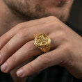 Load image into Gallery viewer, Gold plated griffon signet ring worn on finger, statement fantasy jewelry inspired by ancient mythical guardians, premium lifestyle close-up
