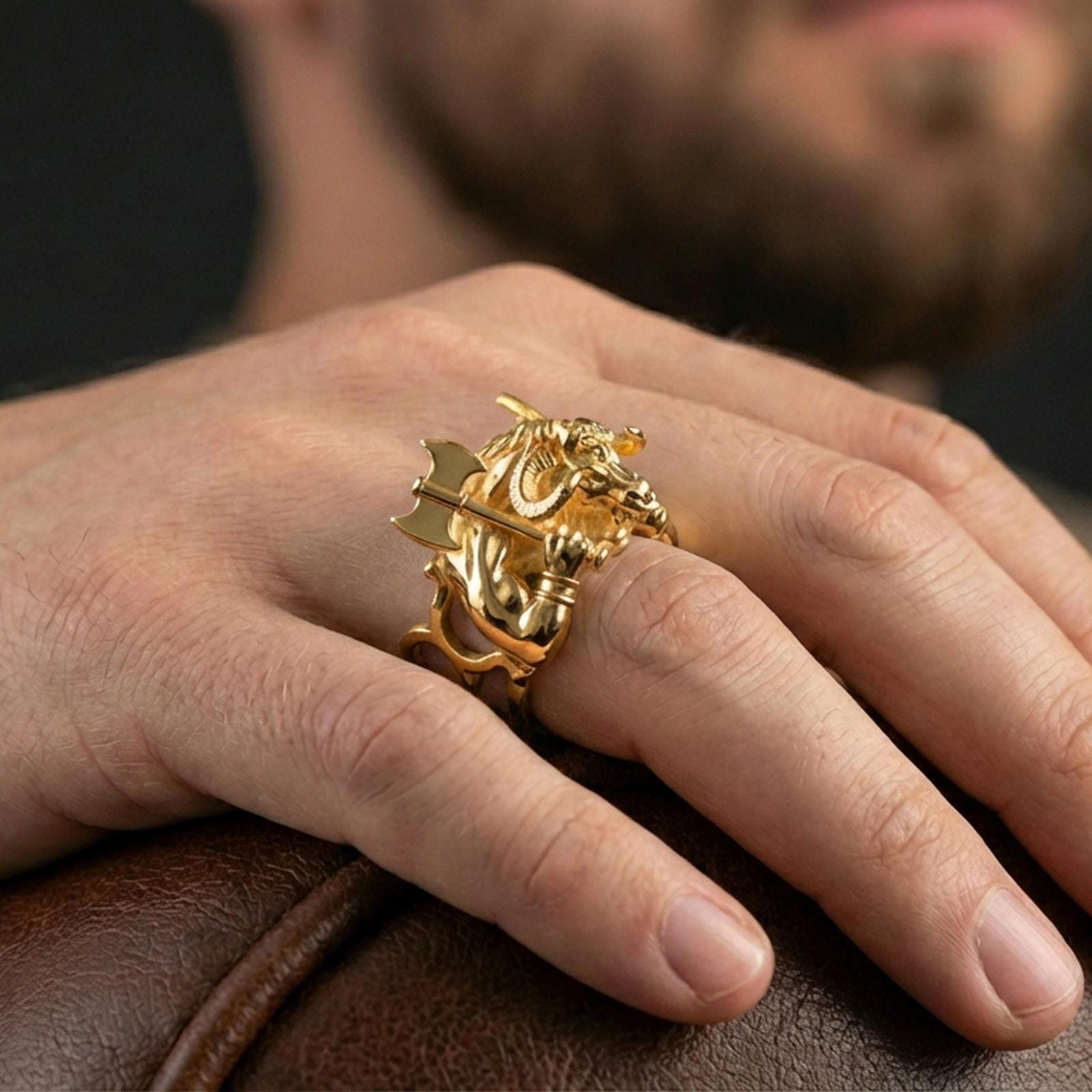 Gold plated Minotaur signet ring worn on finger, statement mythology jewelry inspired by ancient Greek legends, premium lifestyle close-up
