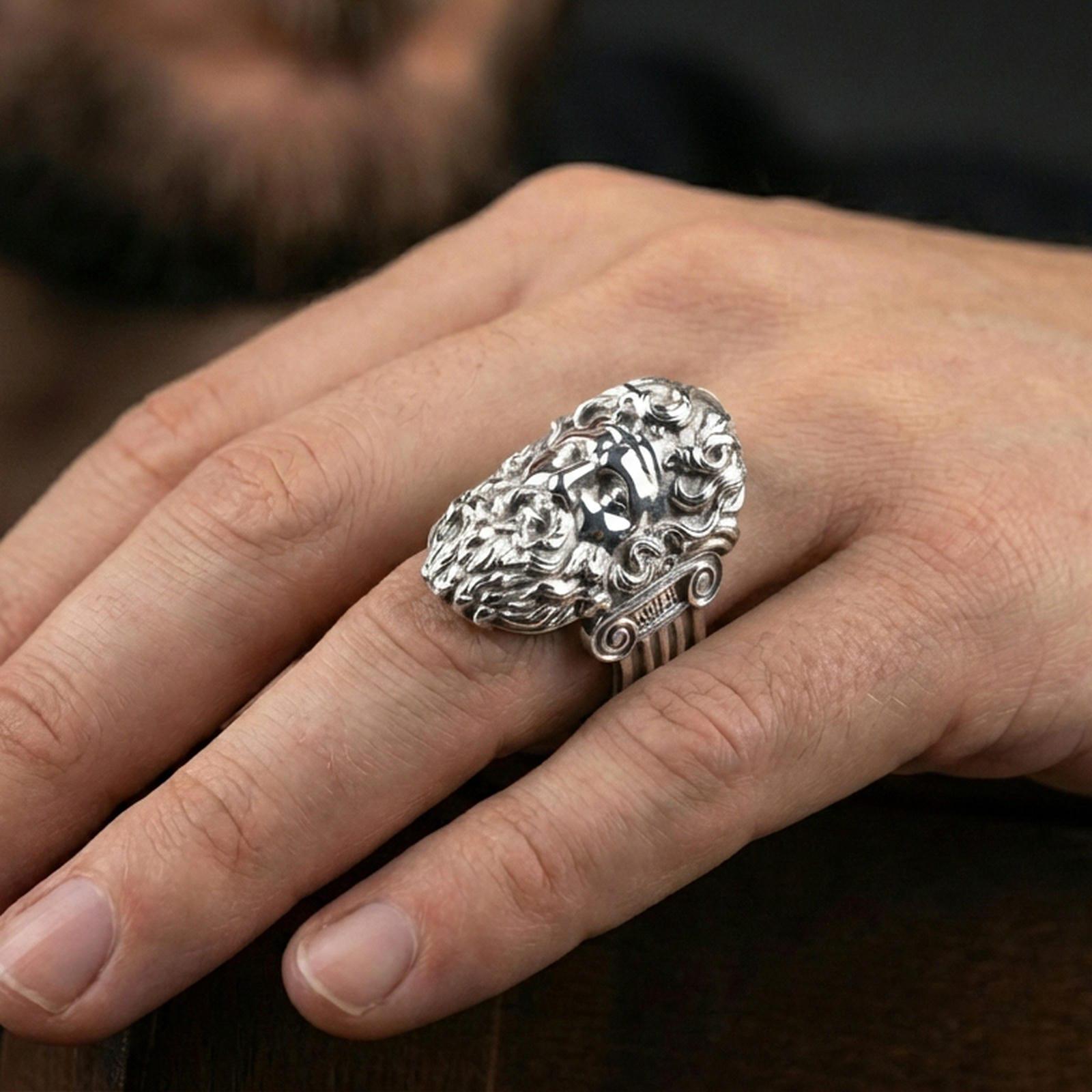 Polished silver Zeus ring on finger highlighting sculpted facial features and classical mythology style, clean lifestyle wear photo