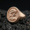 Load image into Gallery viewer, Rose gold plated Medusa ring showcasing detailed ancient Greek Medusa profile and textured background, sharp close-up product photography on volcanic rock
