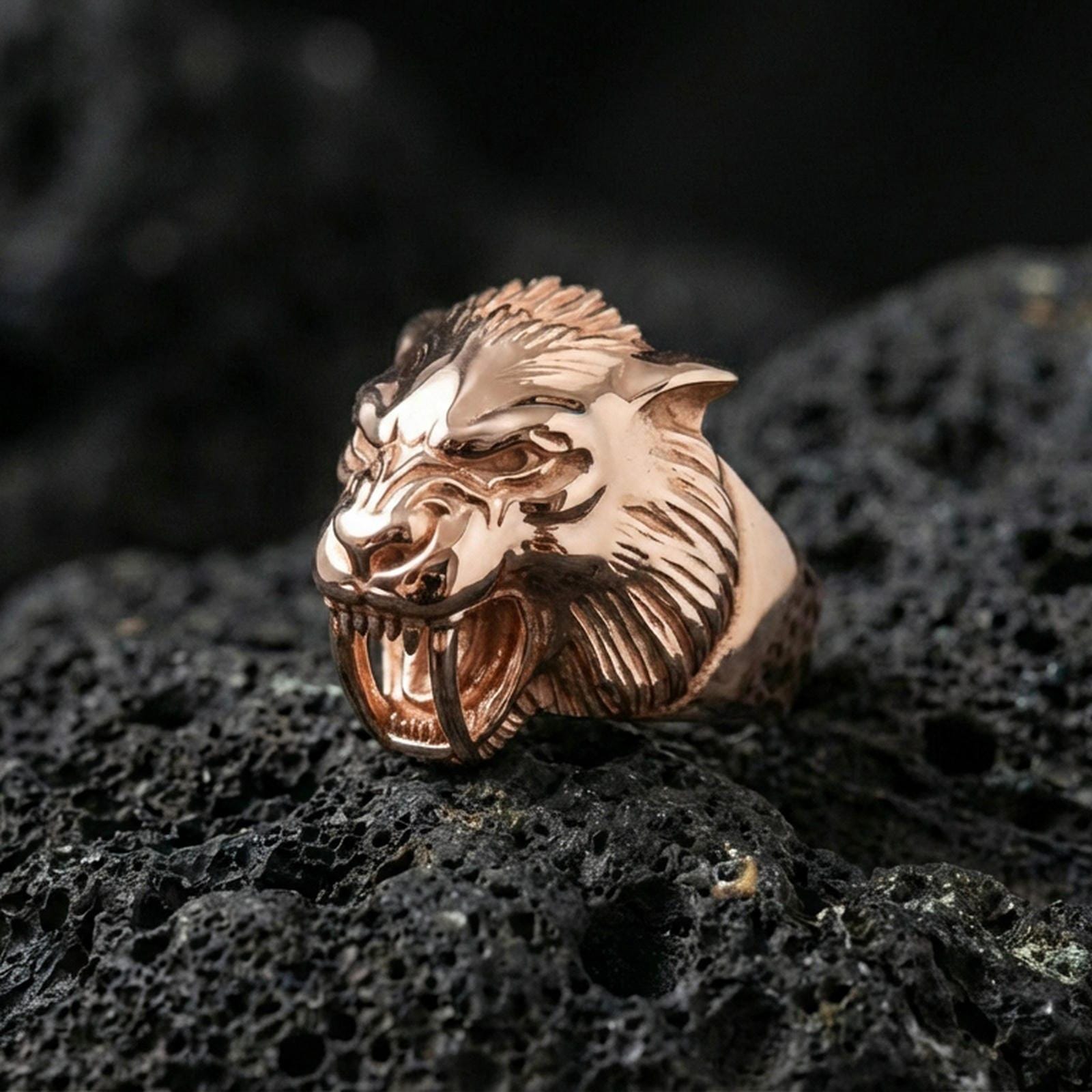 Rose gold plated werewolf ring showcasing gothic wolf head design with sculpted teeth and fur lines, sharp close-up product photography on volcanic rock
