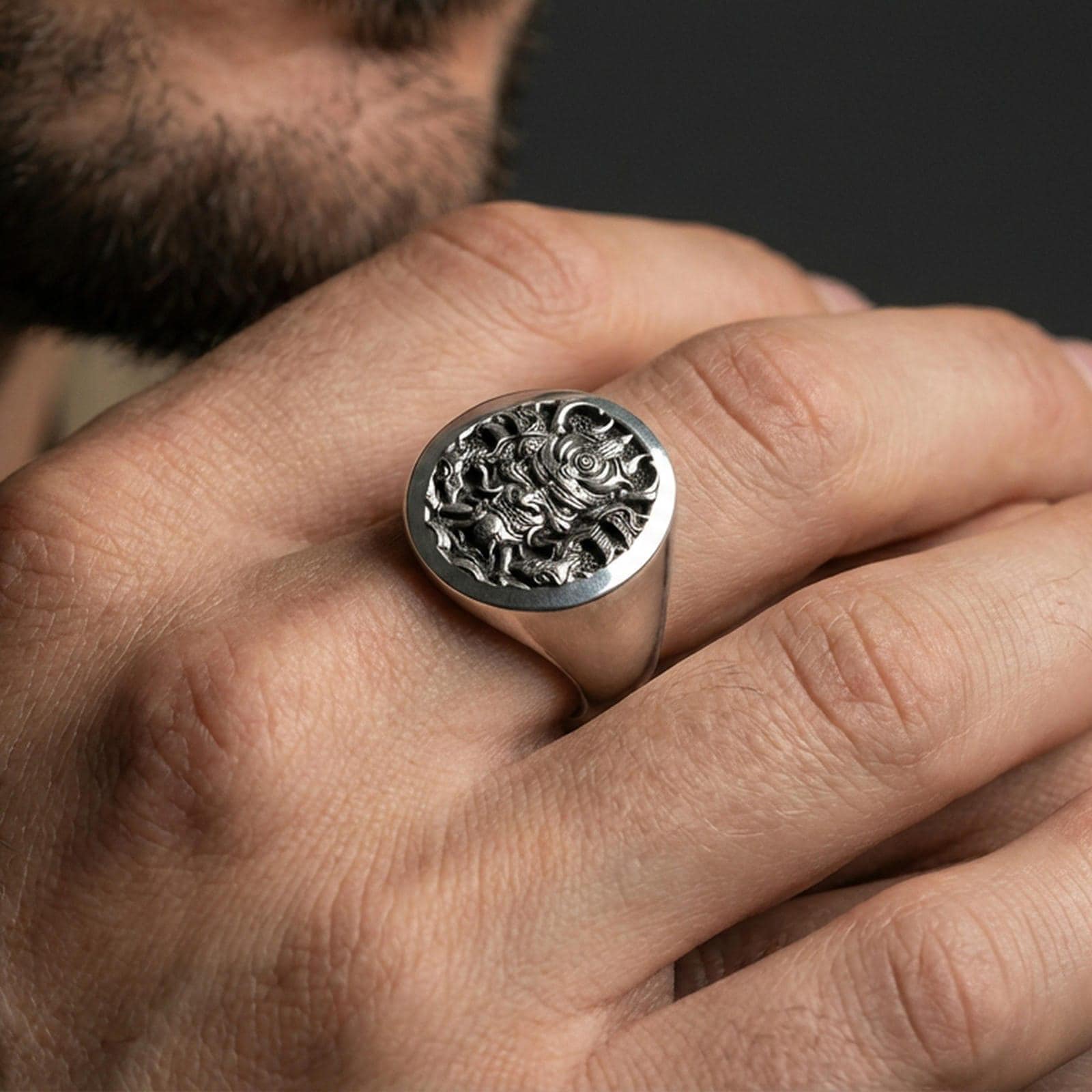 Oxidized sterling silver samurai warrior ring on a human finger, engraved Japanese warrior signet, dark fantasy aesthetic