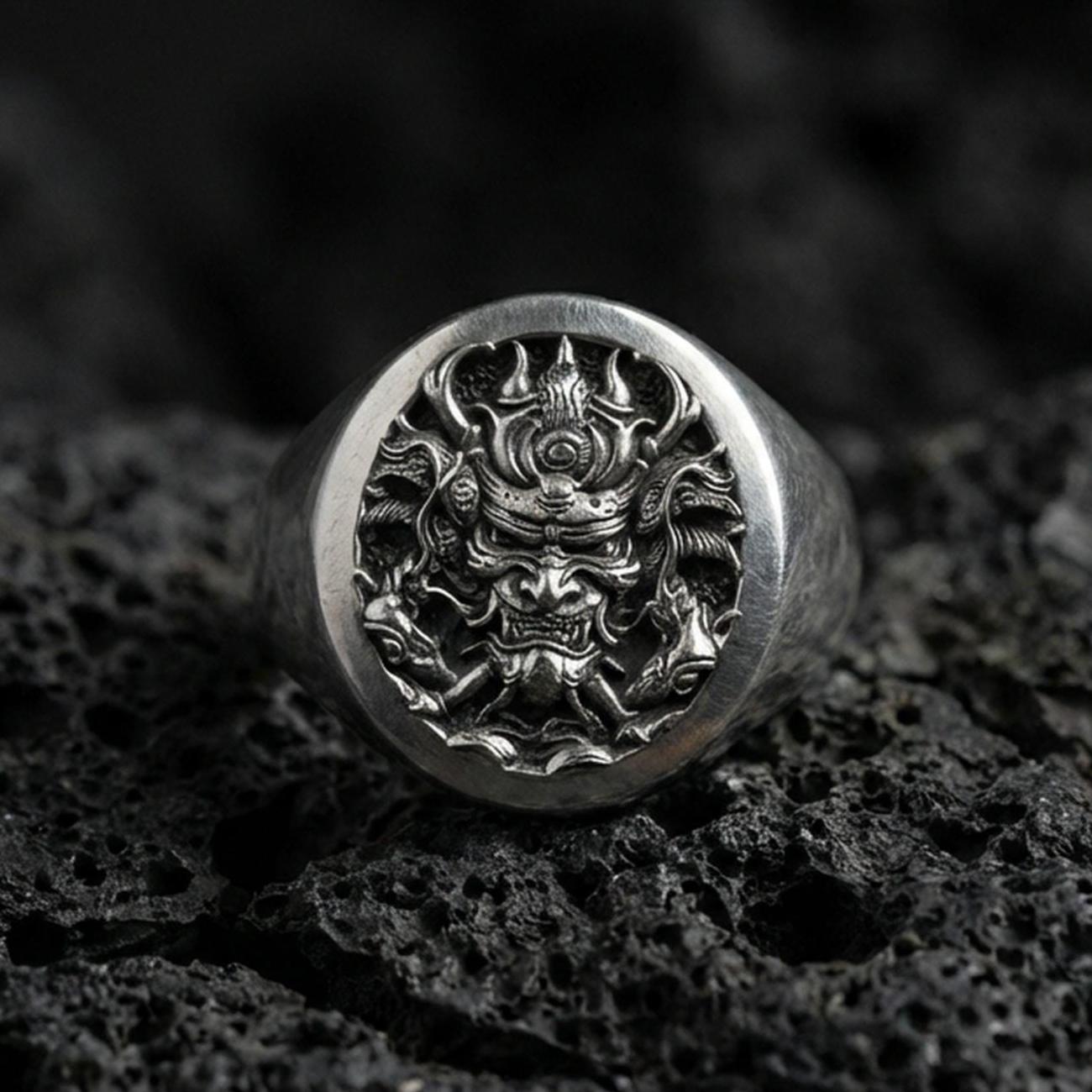 Oxidized sterling silver samurai warrior signet ring on black volcanic stone, detailed Japanese warrior mask engraving, dark fantasy style