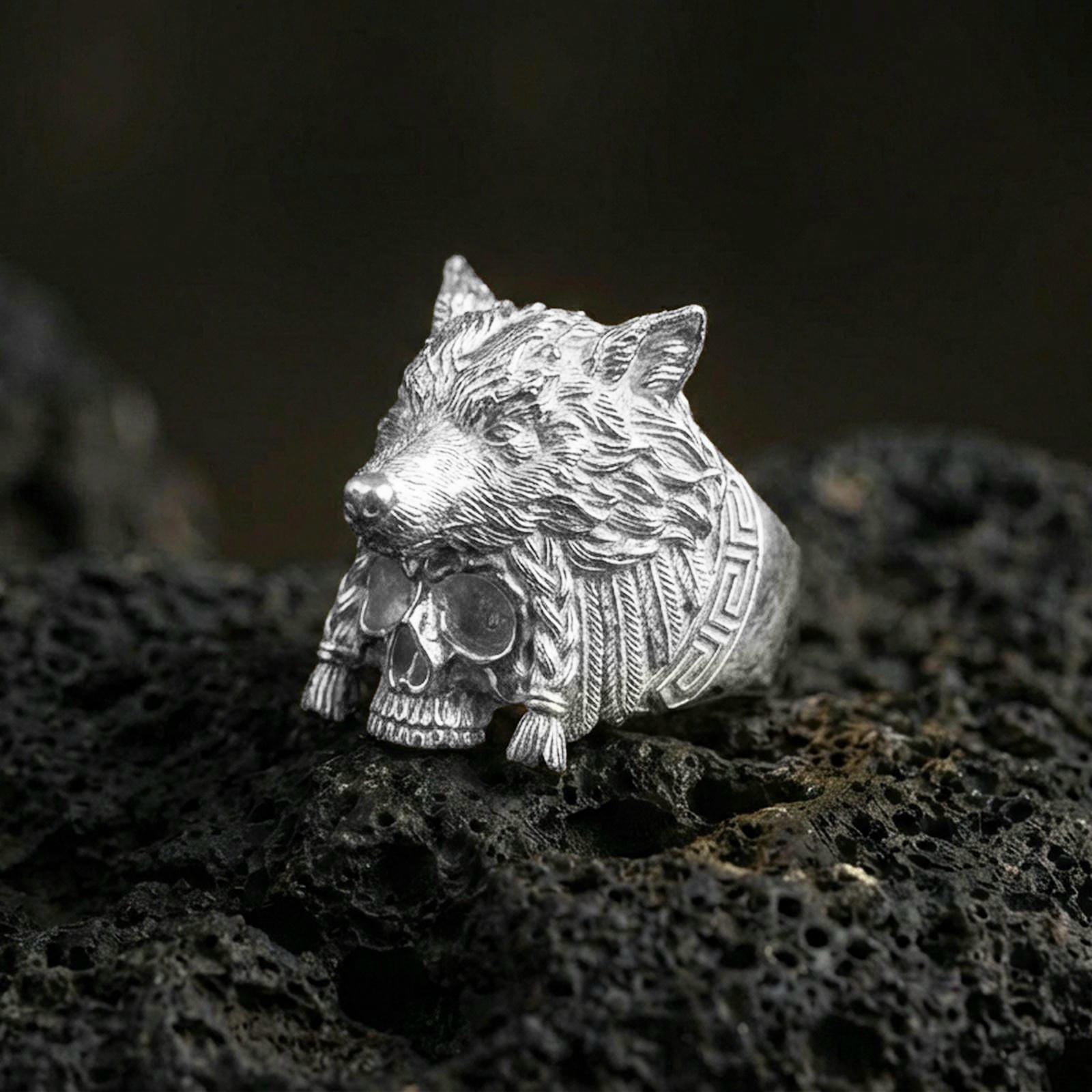 Polished sterling silver wolf headdress skull ring on black volcanic stone, detailed wolf head carving with skull base, bold warrior jewelry