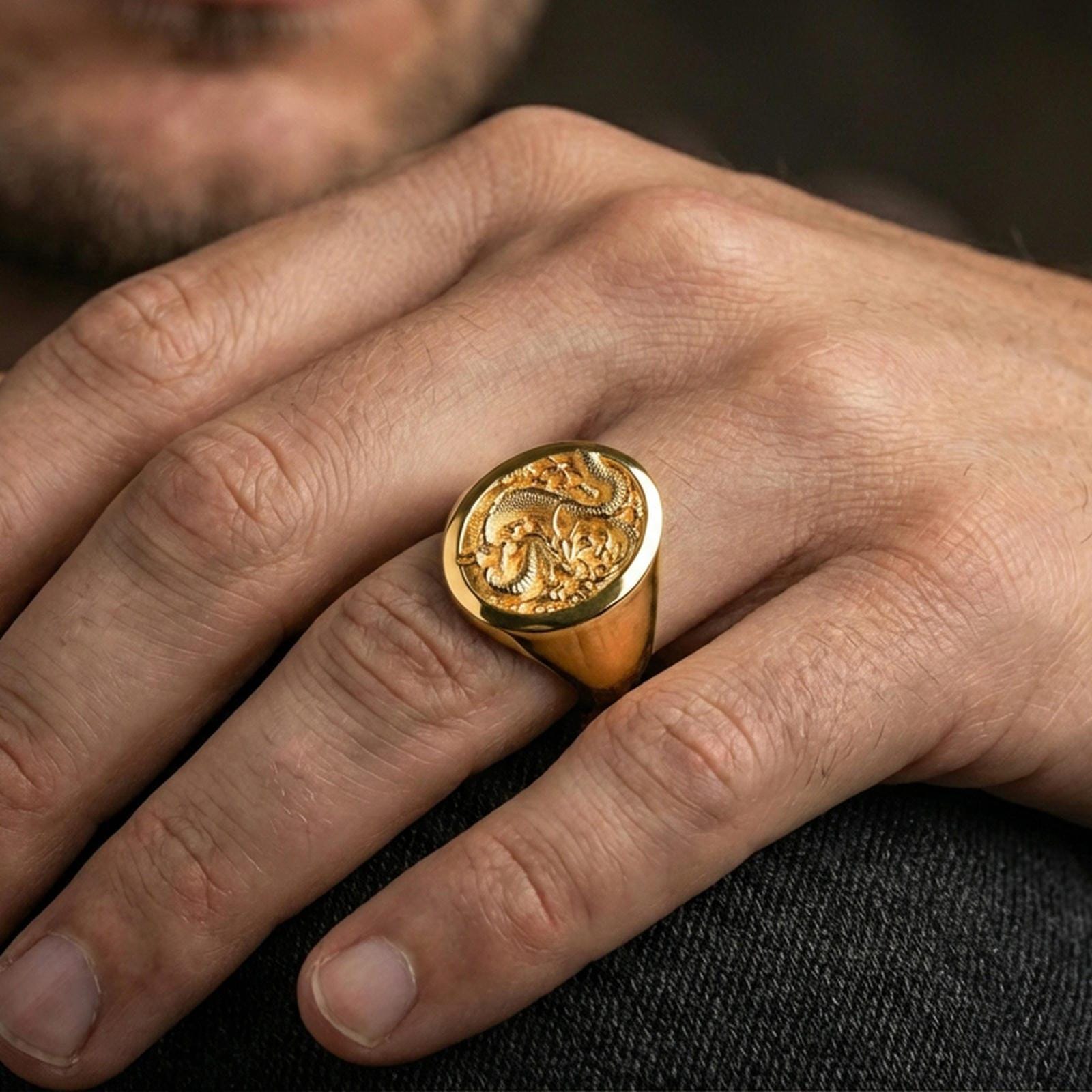 Gold plated Chinese dragon signet ring on a human finger, imperial dragon symbol, lunar new year gift ring