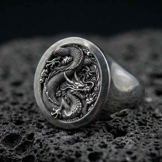 Oxidized sterling silver Chinese dragon signet ring on black volcanic stone, coiled imperial dragon relief, lunar new year jewelry