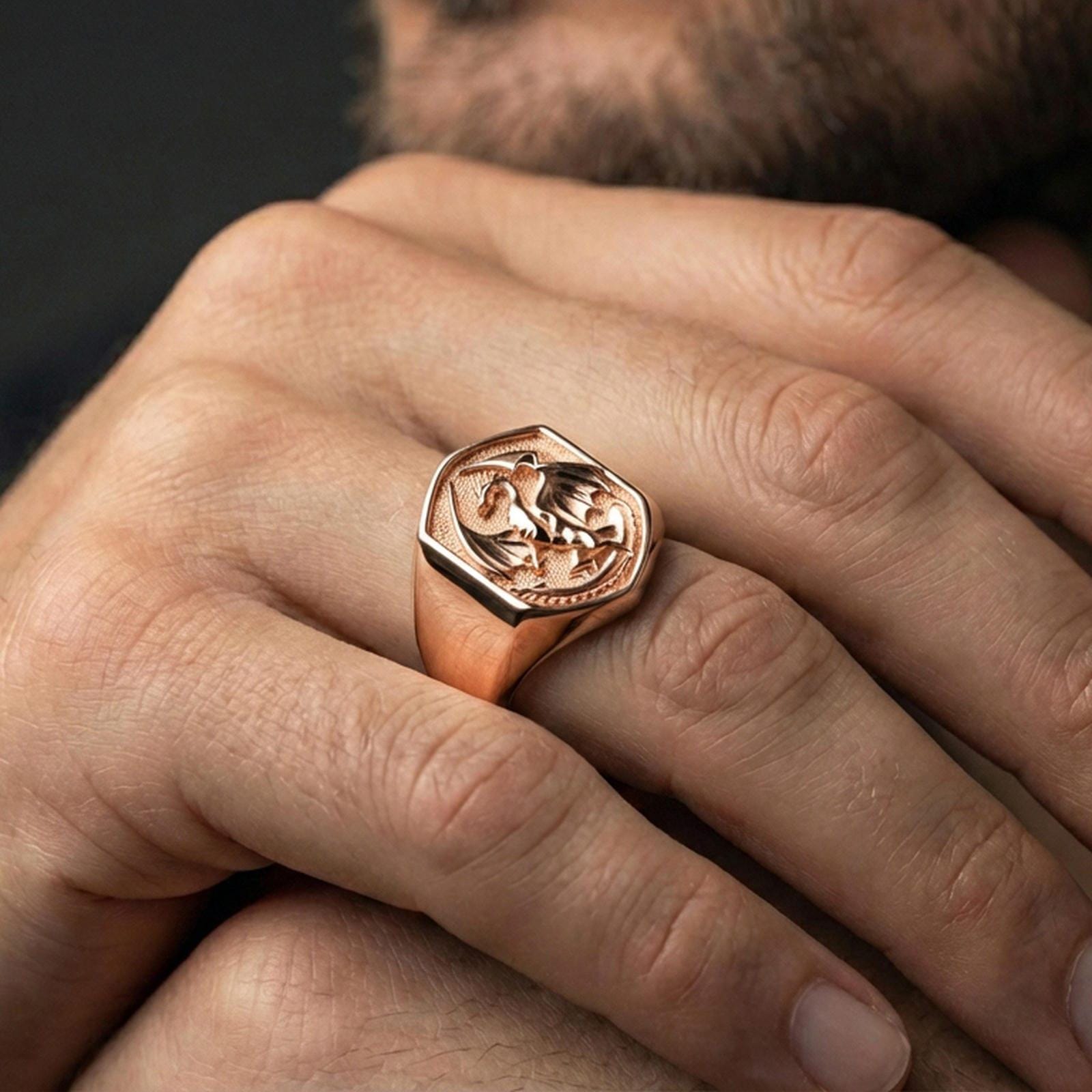 Rose gold plated dragon ring on a human finger, dragon emblem signet ring, dramatic fantasy aesthetic