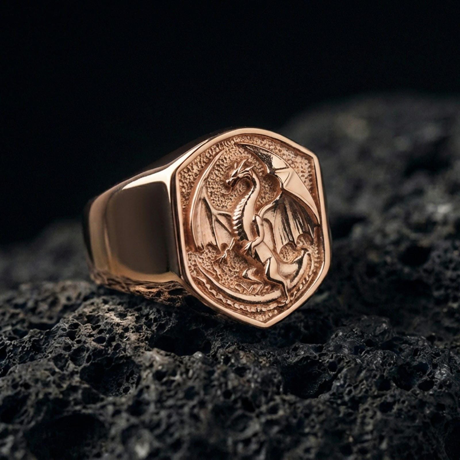 Rose gold plated dragon signet ring on black volcanic stone, sculpted dragon emblem, fantasy-inspired signet style