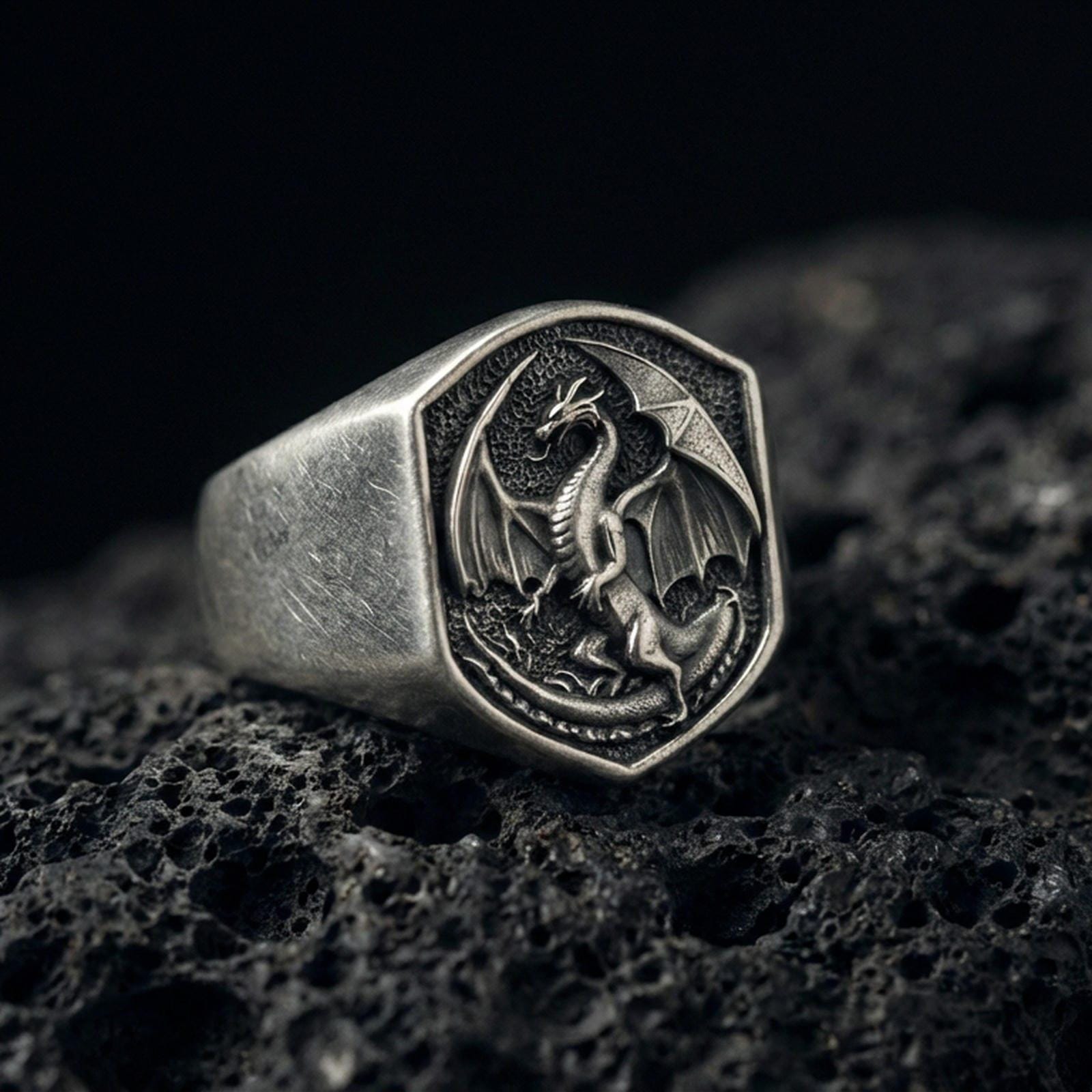 Oxidized sterling silver dragon signet ring on black volcanic stone, winged dragon relief, dark mythologic fantasy jewelry