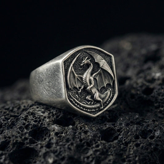 Oxidized sterling silver dragon signet ring on black volcanic stone, winged dragon relief, dark mythologic fantasy jewelry