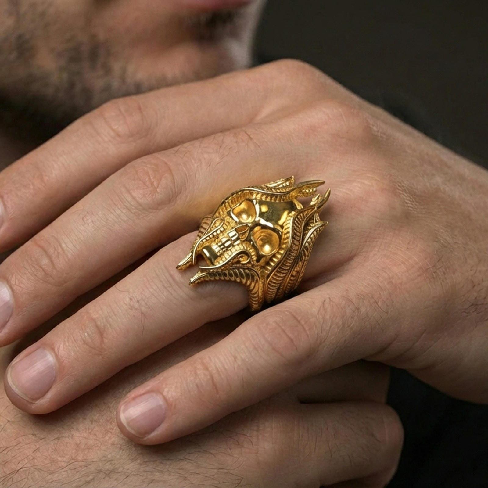 Gold plated lich skull ring worn on a human finger, fantasy wizard skull motif, statement ring