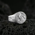 Load image into Gallery viewer, Polished sterling silver wolf and dragon ring on black volcanic stone, mythological animal design, high-detail signet style
