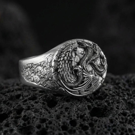 Oxidized sterling silver wolf and dragon ring on black volcanic stone, intertwined fantasy creatures, detailed engraved band