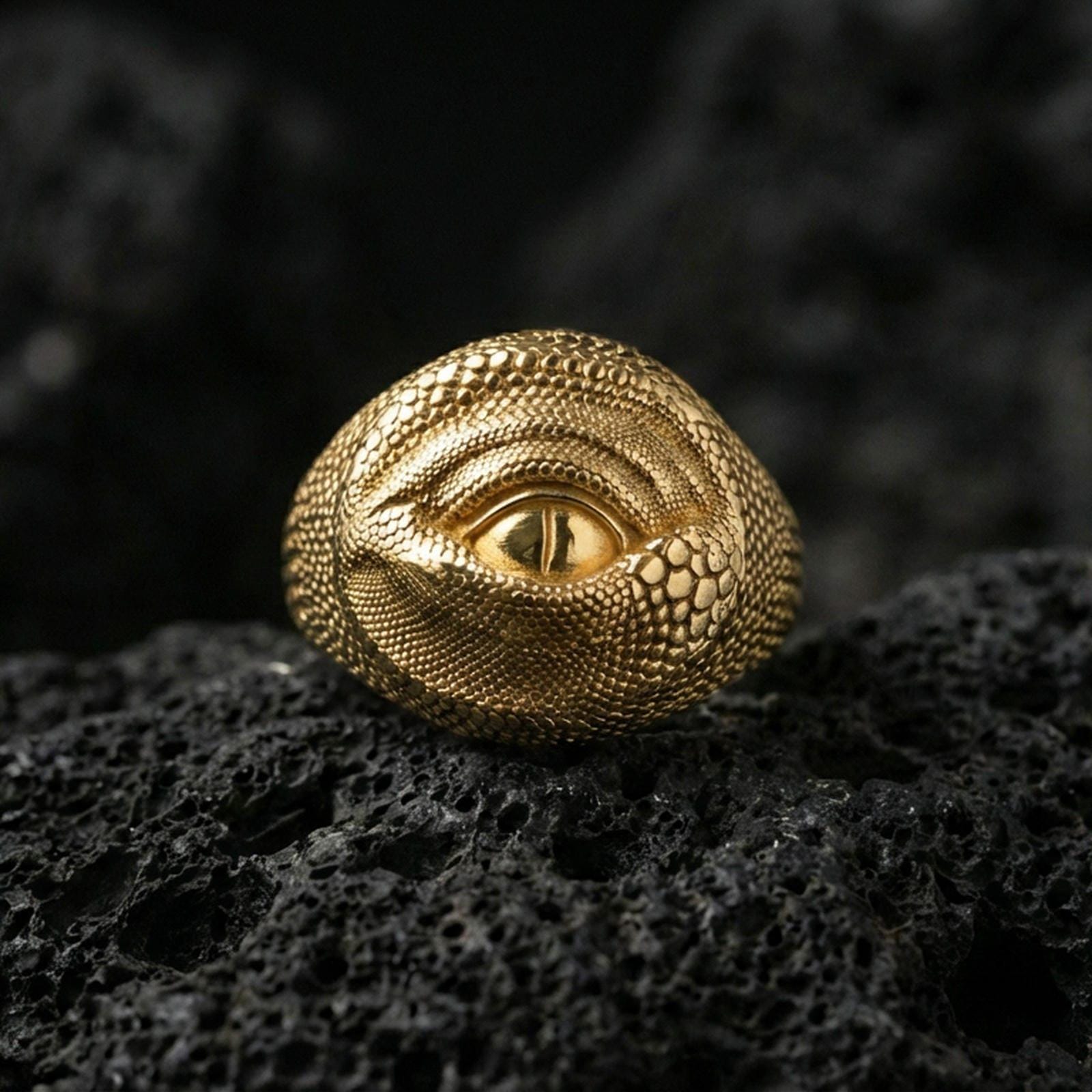 Gold plated dragon eye ring on black volcanic stone, sculpted reptilian eye design, dark fantasy jewelry