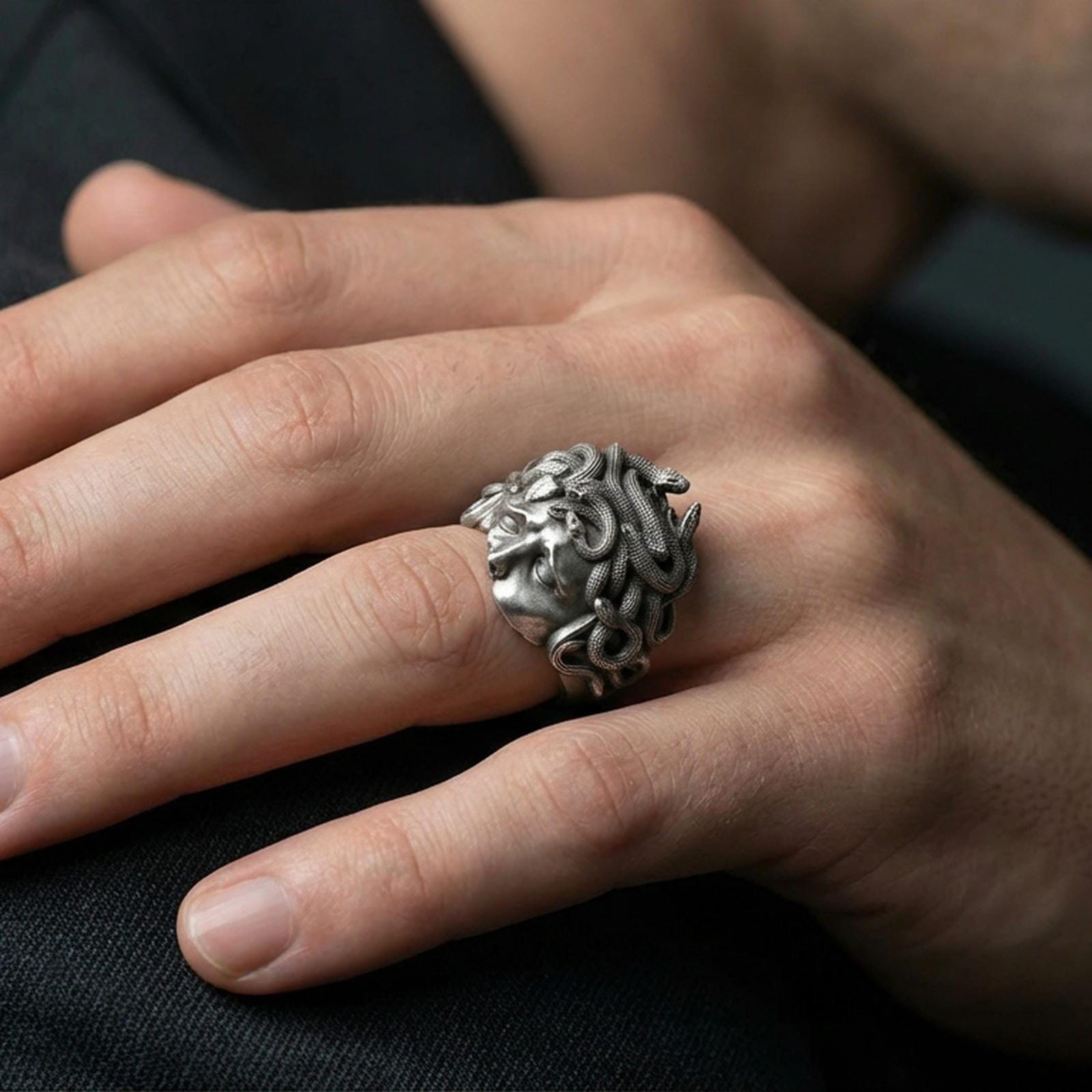 Oxidized sterling silver Medusa head ring worn on a human finger, snake hair gorgon design, Greek mythology statement ring