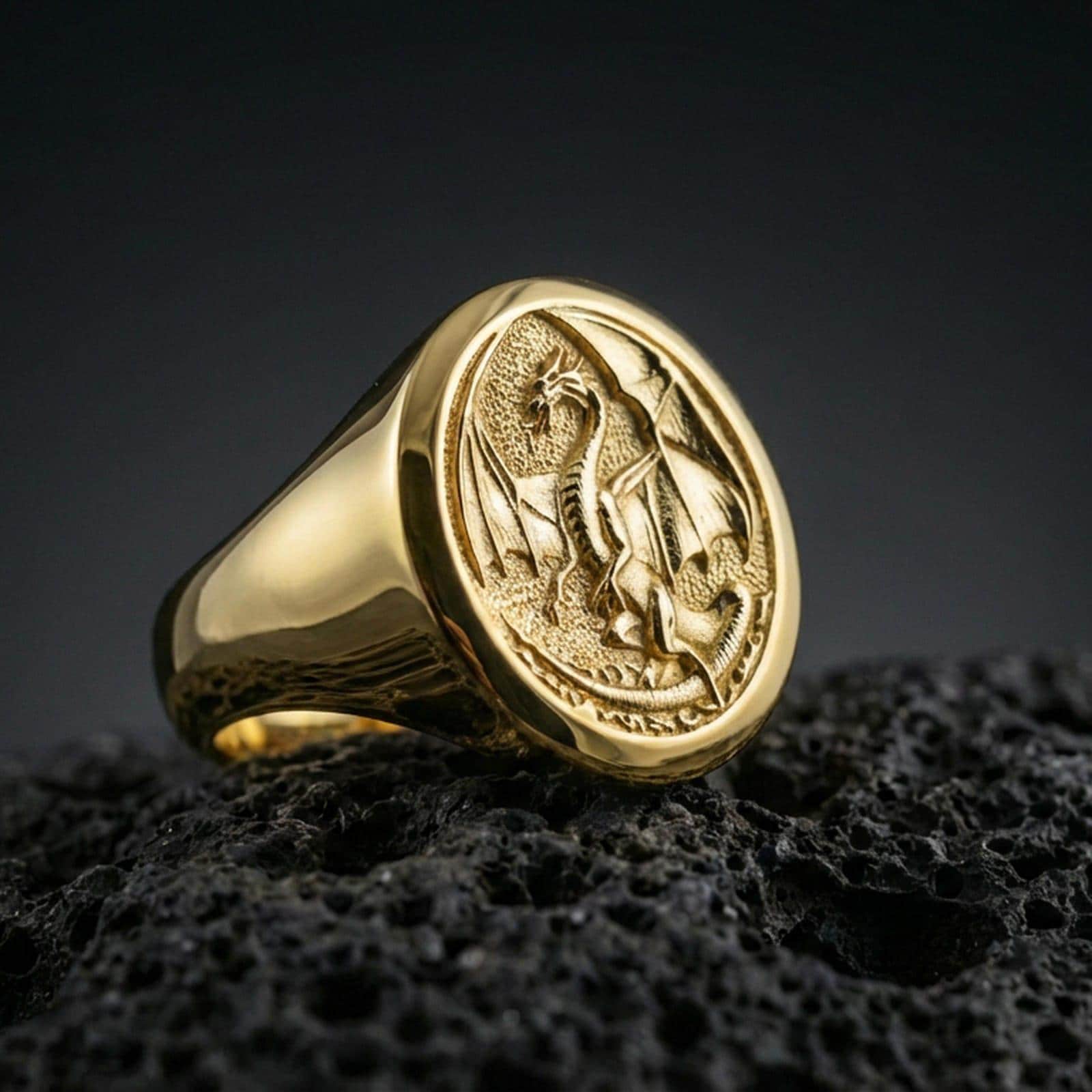 Gold plated dragon signet ring on black volcanic stone, raised winged dragon motif, medieval fantasy ring