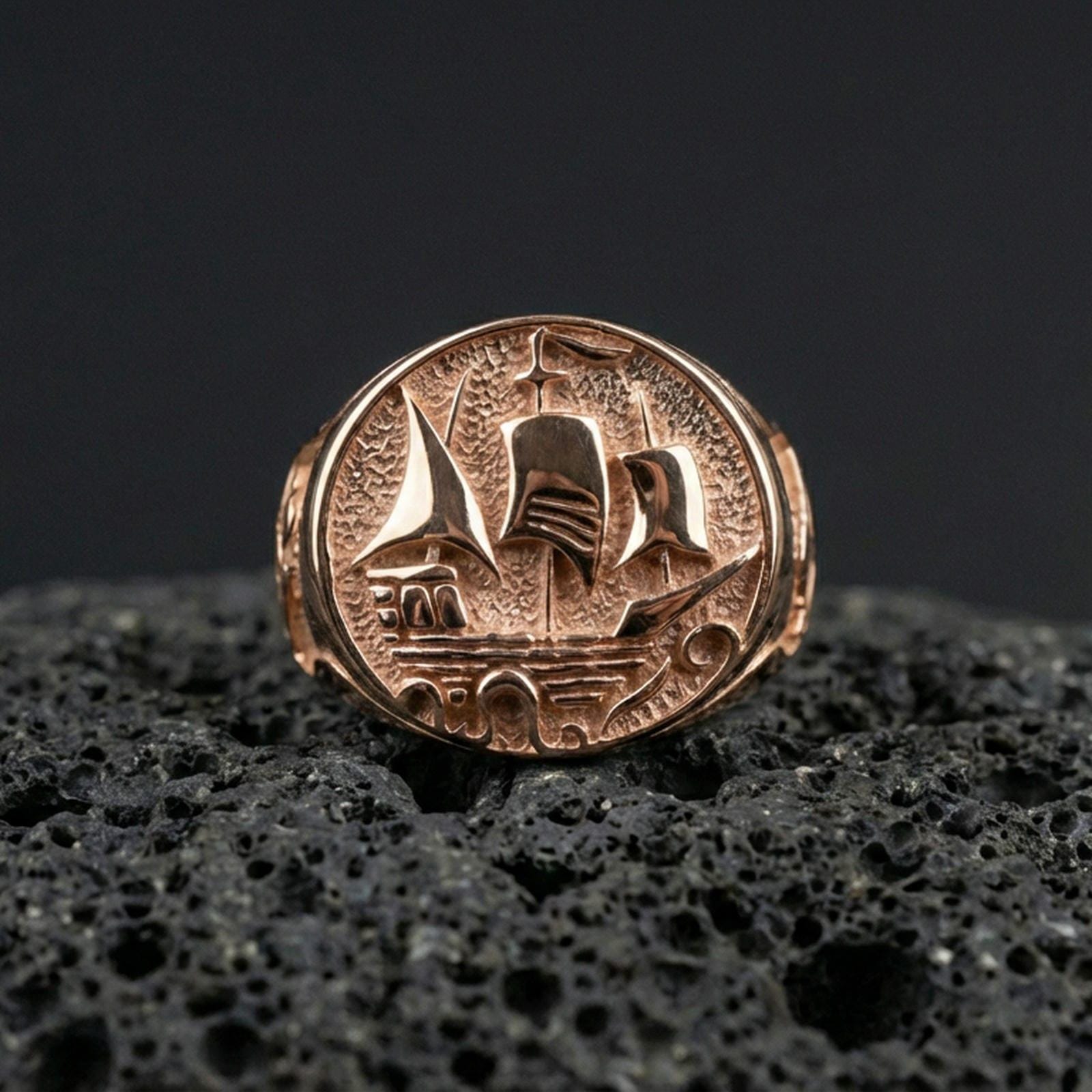 Rose gold plated Flying Dutchman ship signet ring on black volcanic stone, detailed nautical ship emblem, explorer jewelry