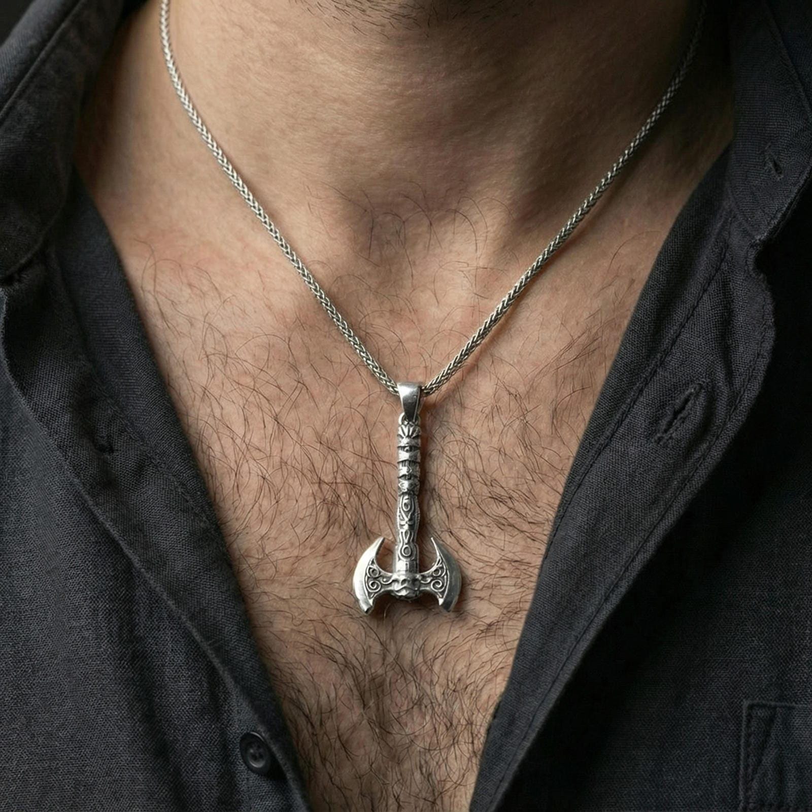 Polished sterling silver Viking labrys axe necklace pendant on a human neck, engraved warrior axe design, braided chain