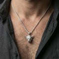 Load image into Gallery viewer, Polished sterling silver bull head necklace pendant on a human neck, Taurus zodiac horned bull charm, braided chain
