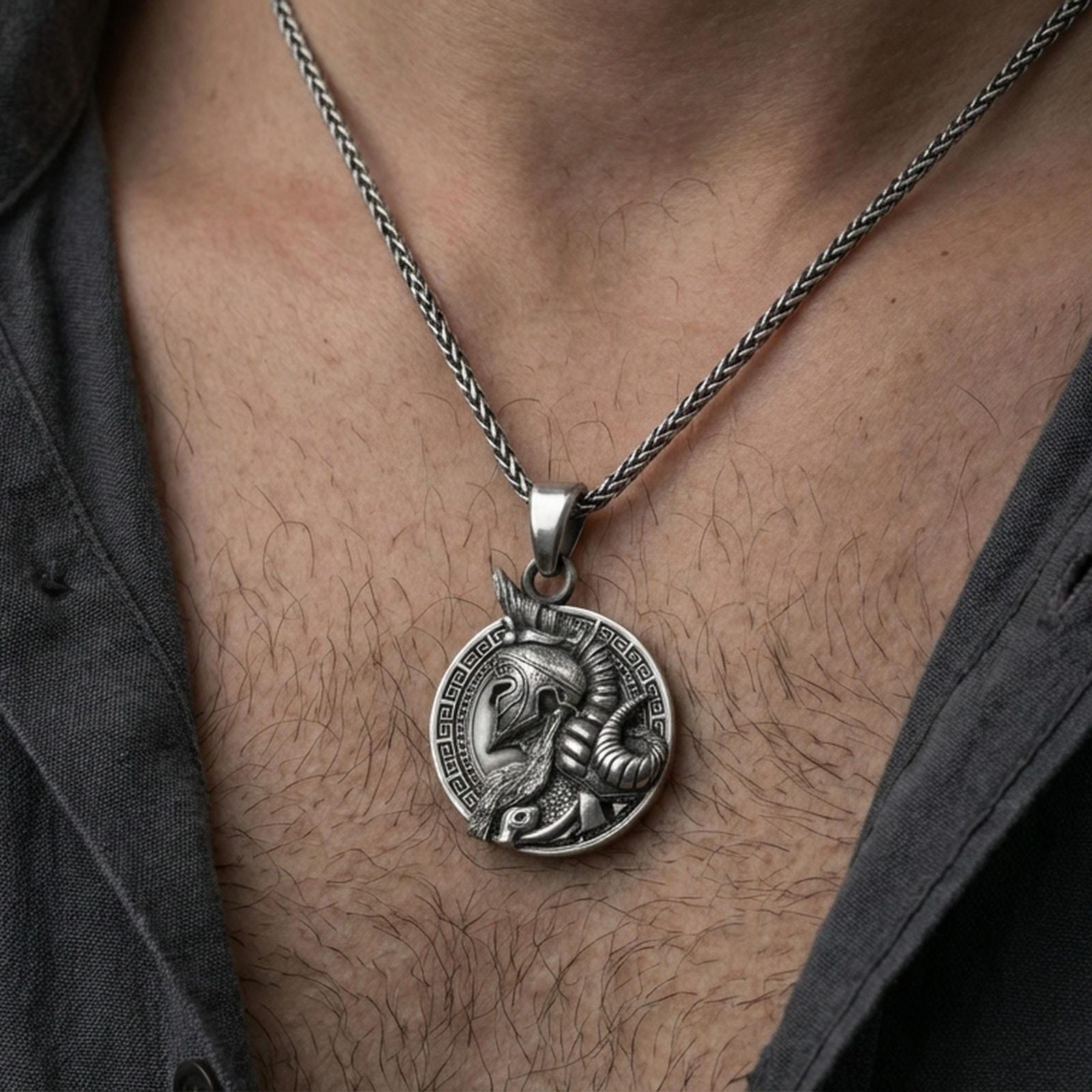Oxidized sterling silver Viking warrior pendant worn on neck on a braided chain, centered chest framing, moody lifestyle studio shot