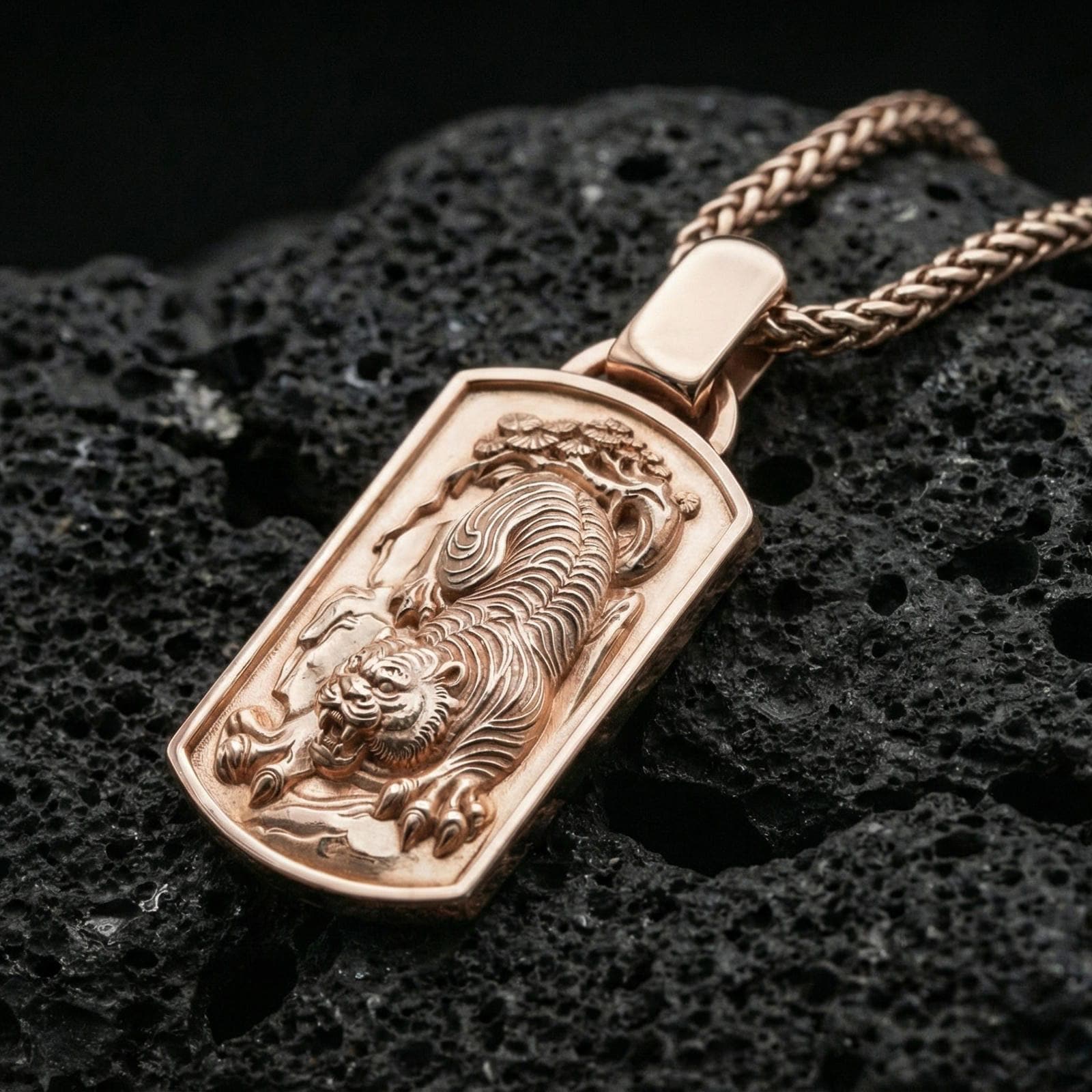 Rose gold plated zodiac tiger pendant on matte volcanic stone, intricate tiger relief and beveled frame edges, sharp macro focus