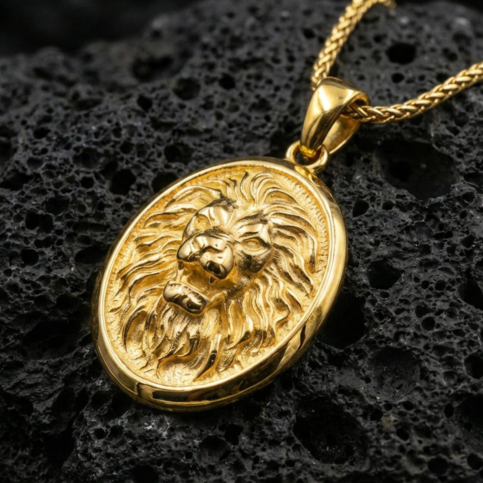 Gold plated roaring lion oval pendant on porous volcanic rock backdrop, bold lion face relief with textured background, high-contrast lighting