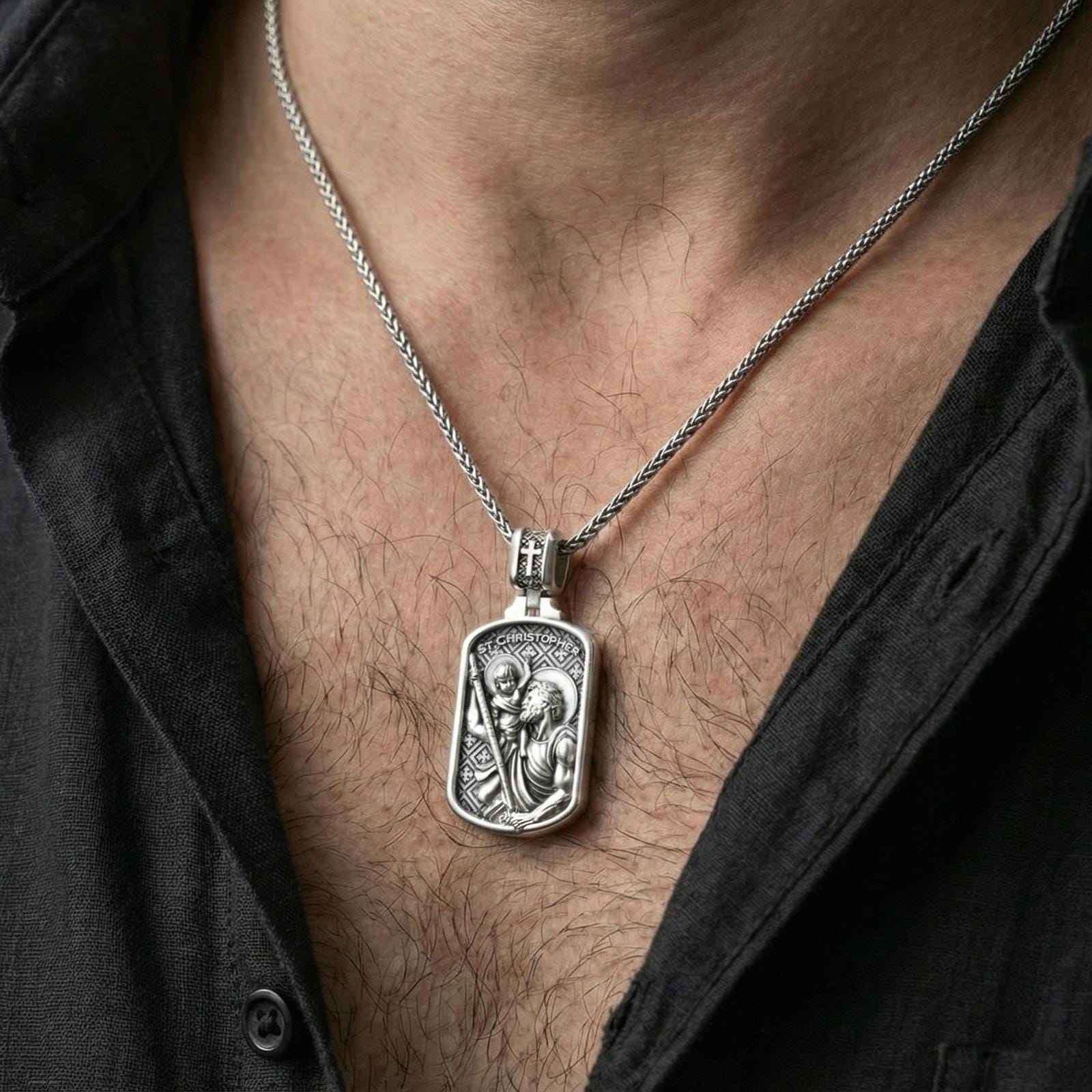 Polished silver St Christopher medal necklace worn on neck, close lifestyle crop, clear saint relief and engraved text details