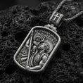 Load image into Gallery viewer, Oxidized sterling silver Saint Christopher pendant on textured volcanic rock, rectangular medal with saint carrying child relief, macro studio shot
