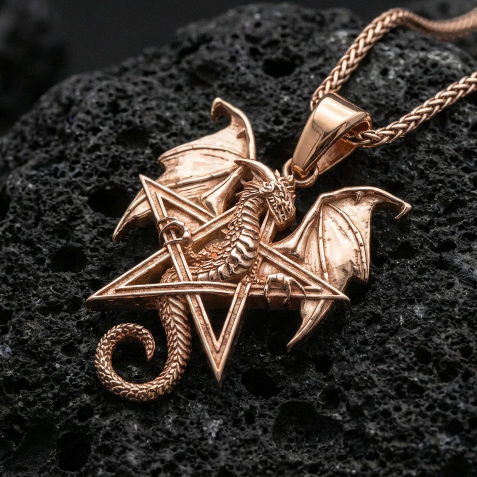 Rose gold plated dragon pentagram pendant on matte volcanic stone, intricate scale texture and wing relief on star frame, sharp macro focus
