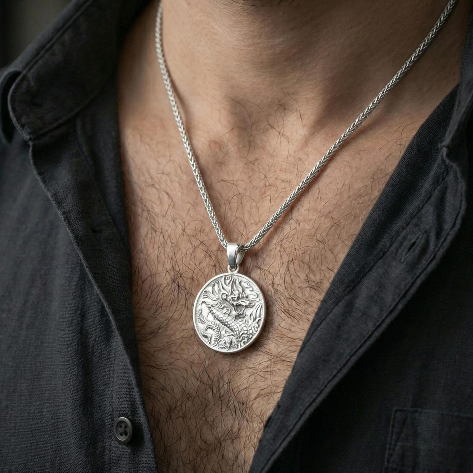 Polished silver Chinese dragon coin necklace worn on neck, close lifestyle crop, clear dragon relief and wave pattern details