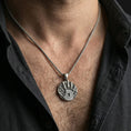 Load image into Gallery viewer, Oxidized sterling silver Skyrim Dark Brotherhood pendant worn on neck on a braided chain, centered chest framing, moody lifestyle studio shot
