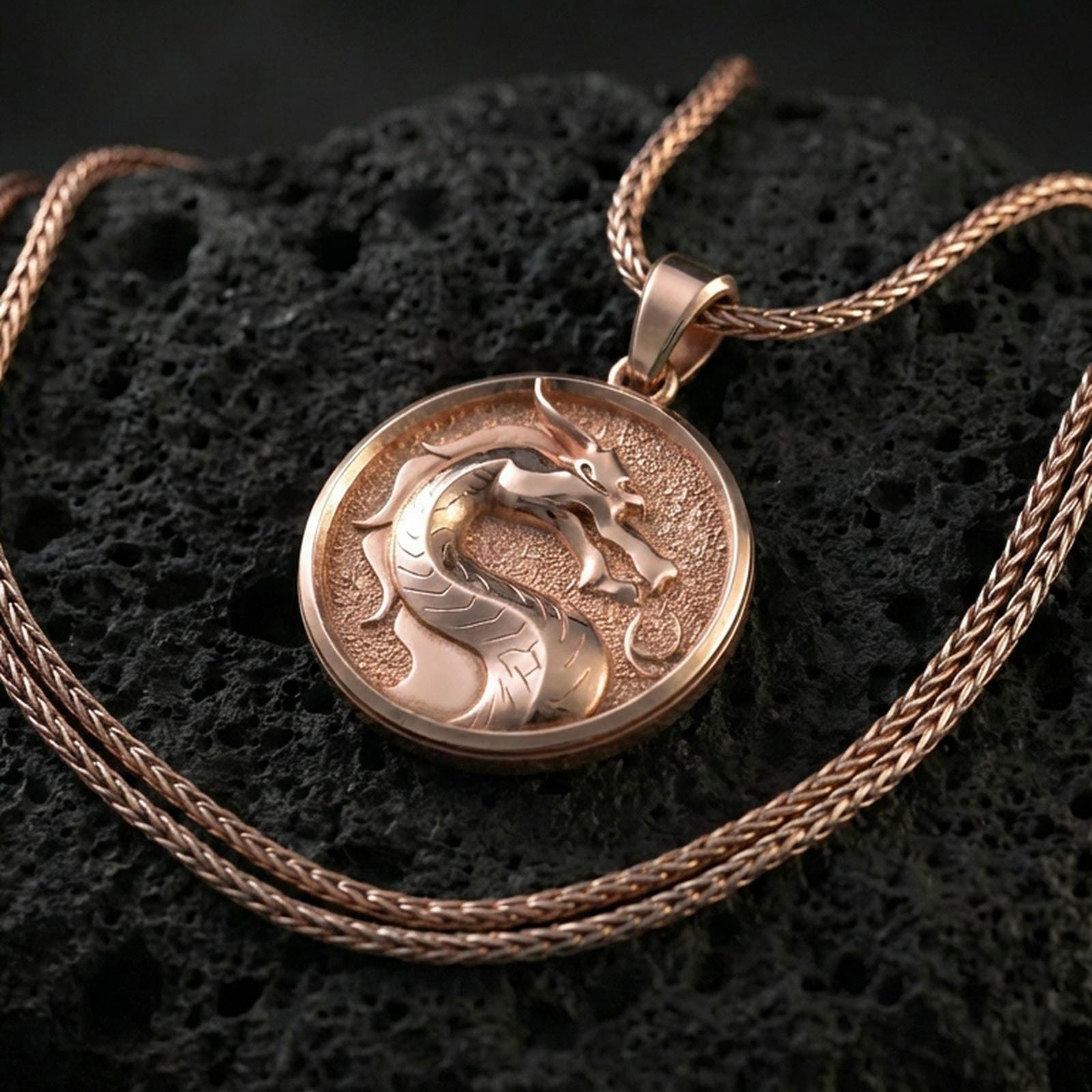 Rose gold plated Mortal Kombat dragon medallion on porous volcanic stone surface, raised dragon head emblem with textured field, sharp focus
